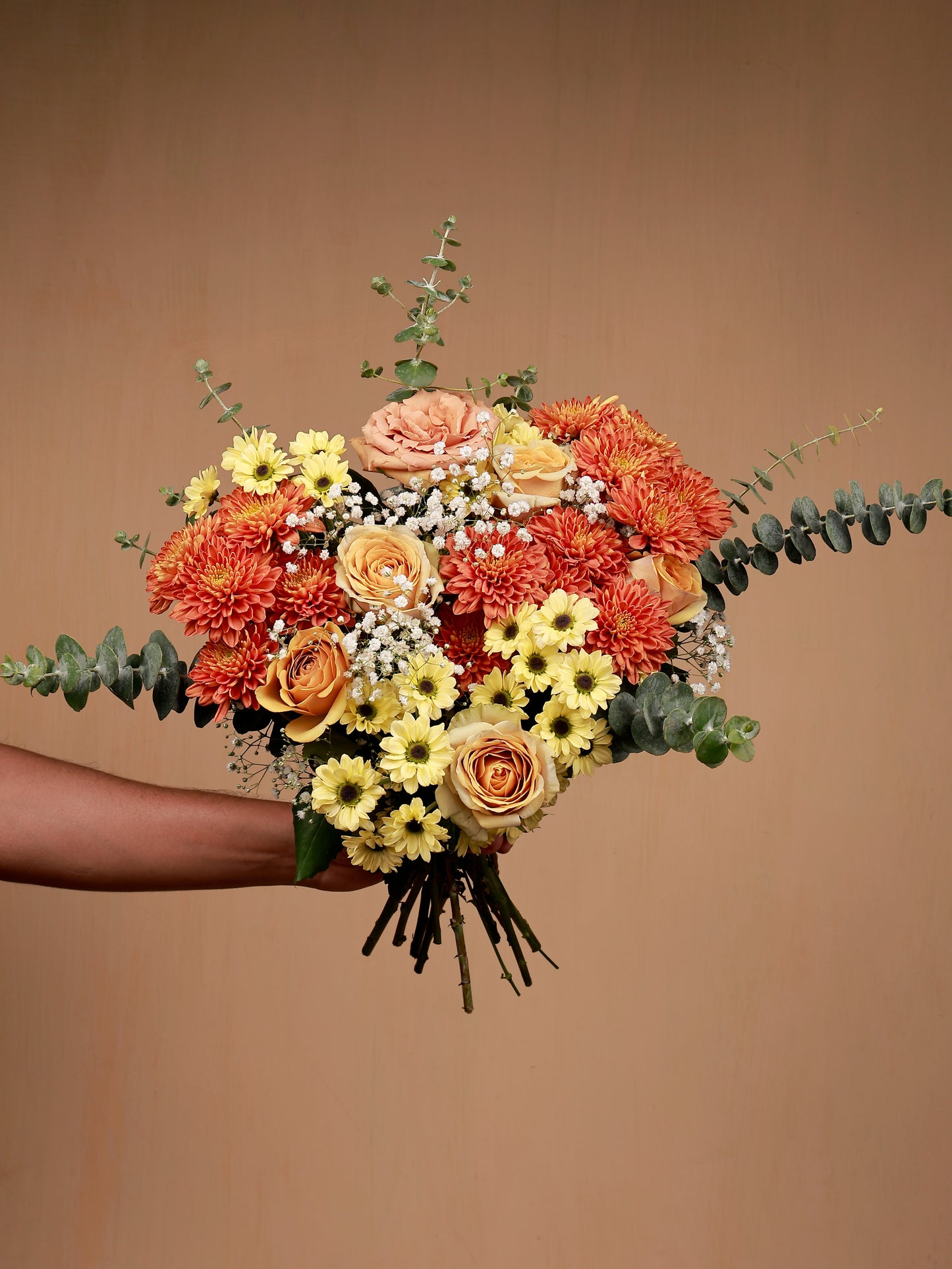 orange and yellow flower bouquet in hand