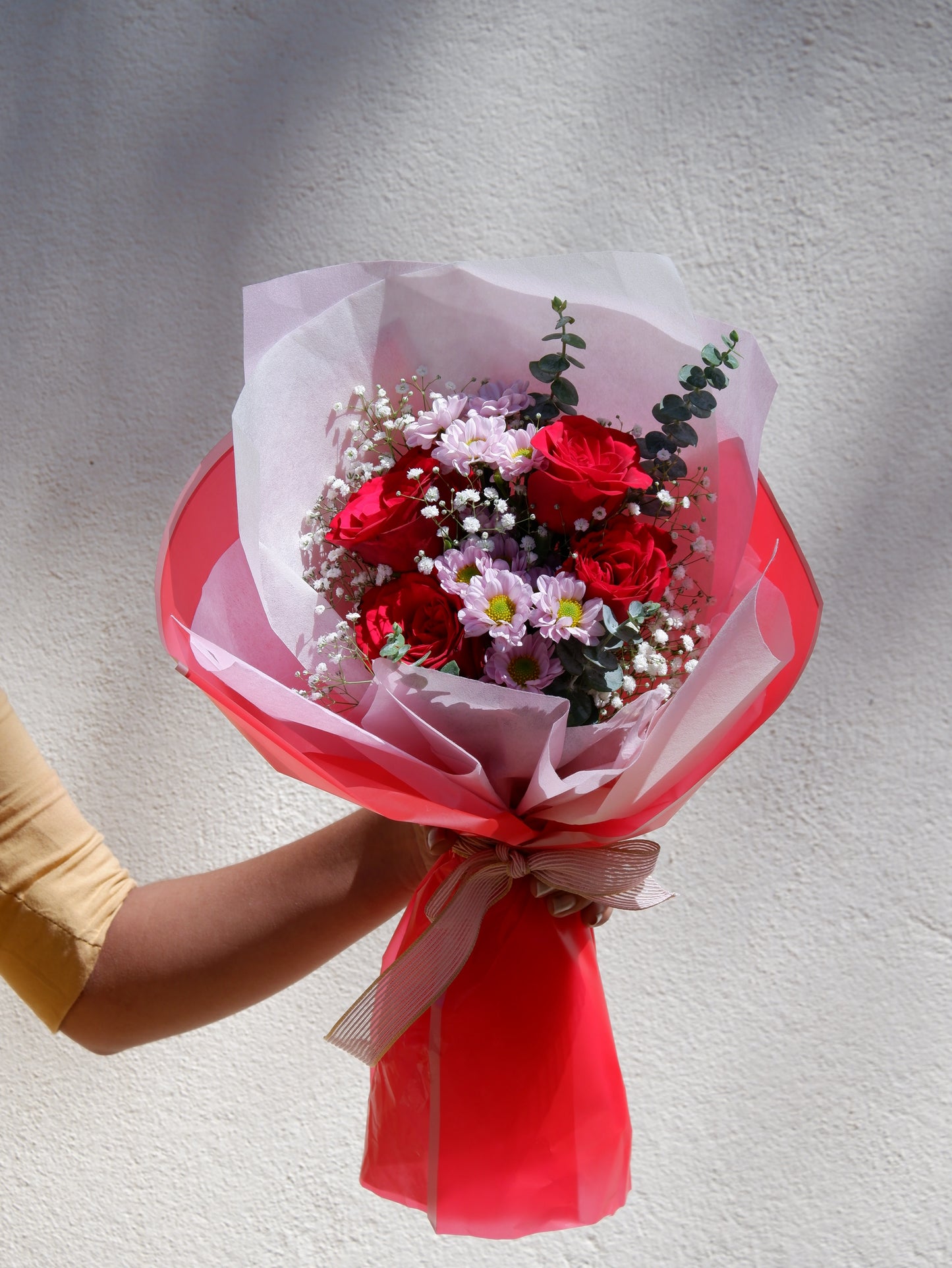 A bouquet of red roses with pink santini