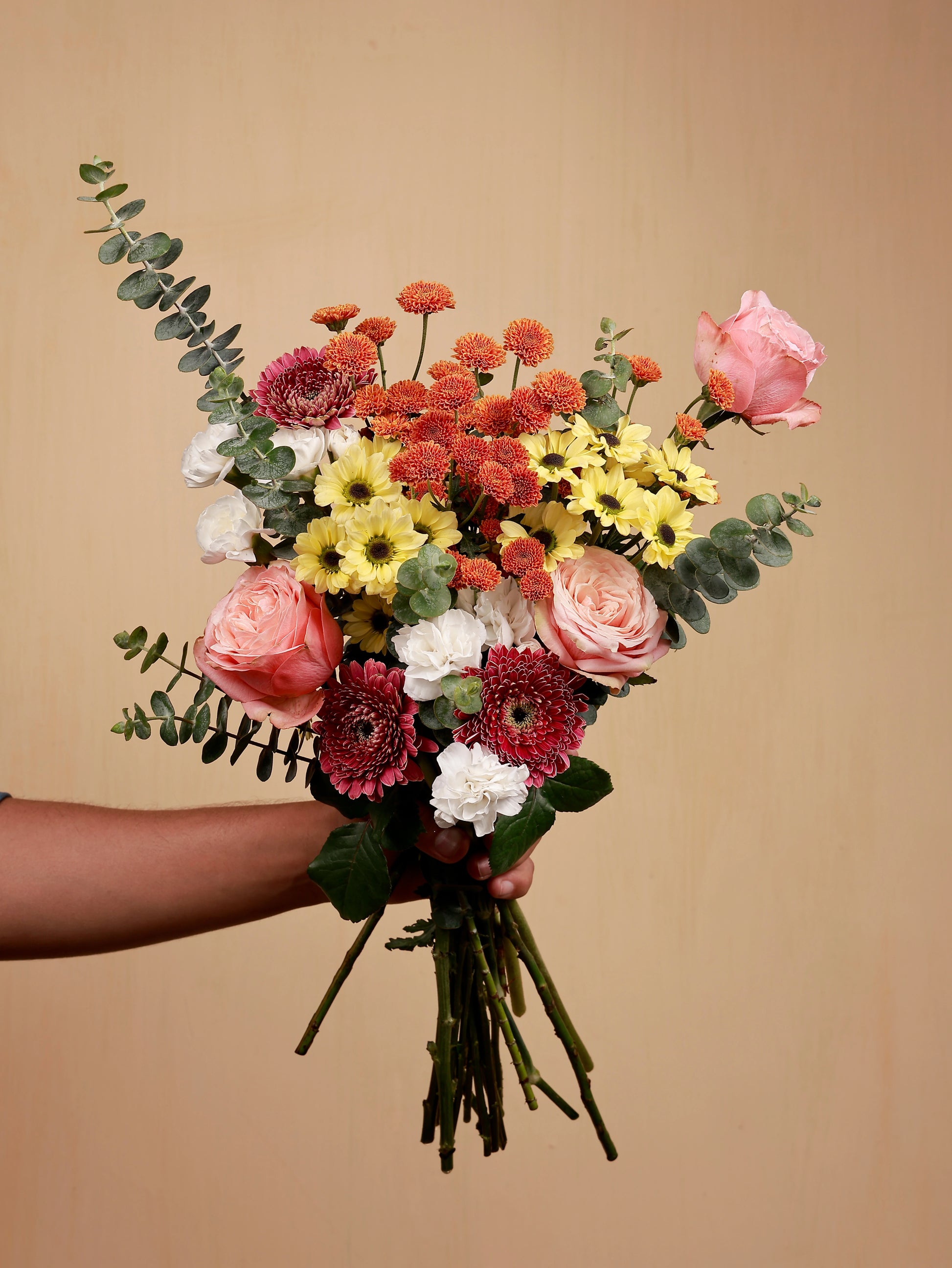 A mix bouquet of flowers in hand
