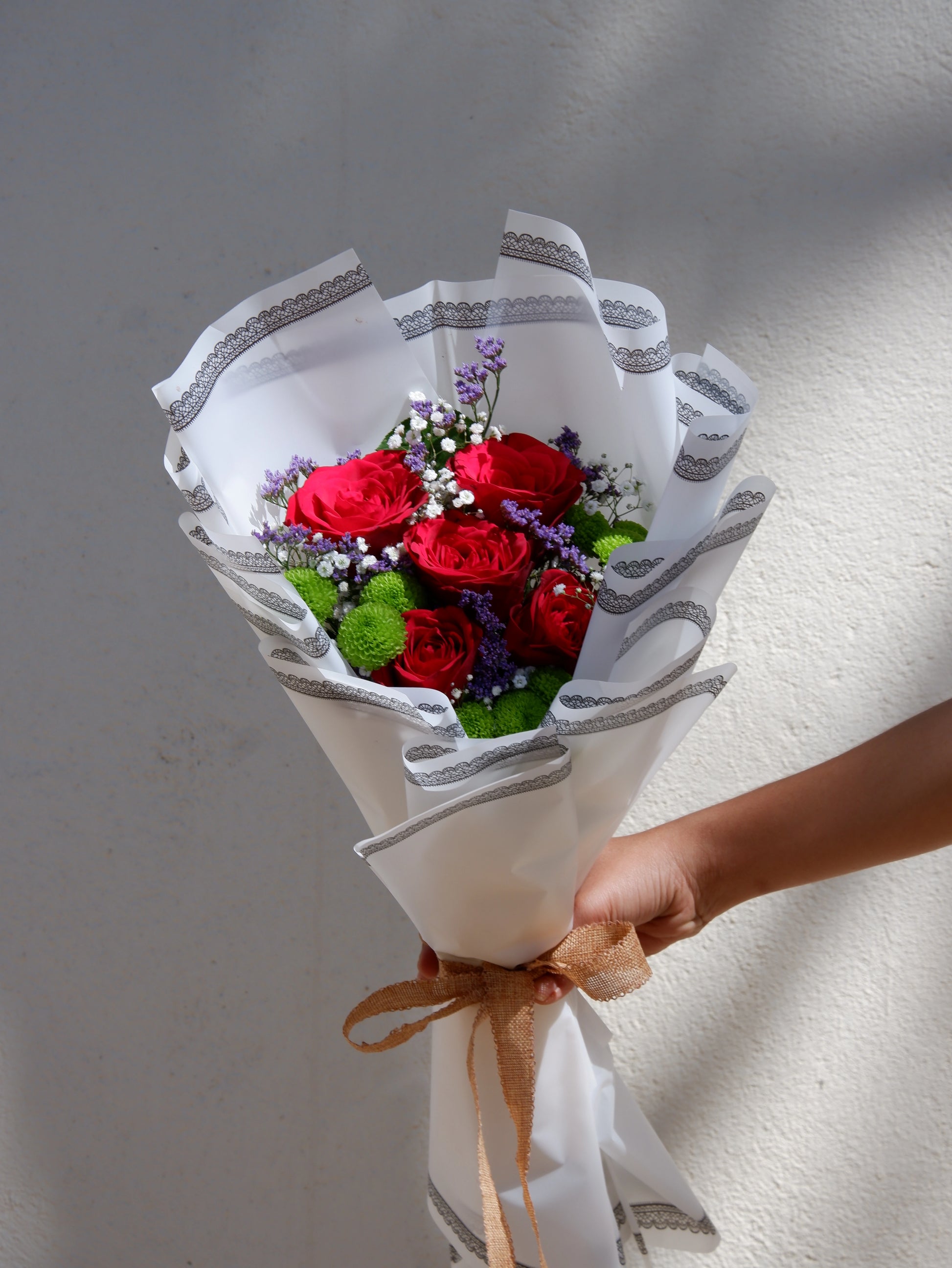 A bouquet of red rose with green button and gypso